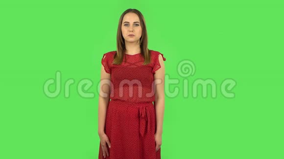 穿着红色衣服的温柔困惑的女孩在说哎呀和耸耸肩绿色屏幕视频的预览图