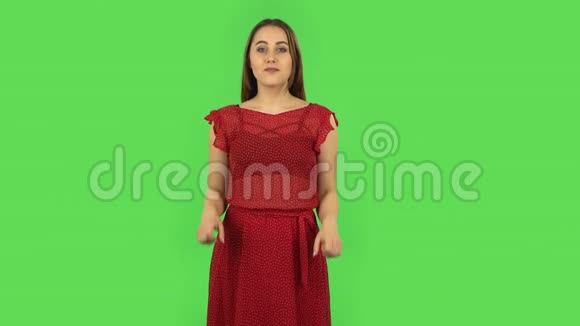 穿着红色衣服的温柔女孩指着手指绿色屏幕视频的预览图