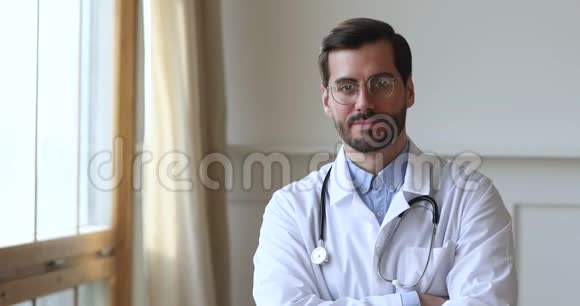 微笑的医生穿着制服看着摄像机站在办公室视频的预览图