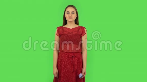 一个穿着红色连衣裙的小女孩正在打开一个小盒子里面装着一个惊喜她对自己看到的东西非常失望绿色屏幕视频的预览图