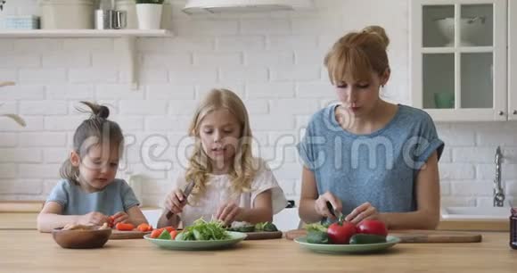 快乐的年轻妈妈教有趣可爱的小女儿准备食物视频的预览图