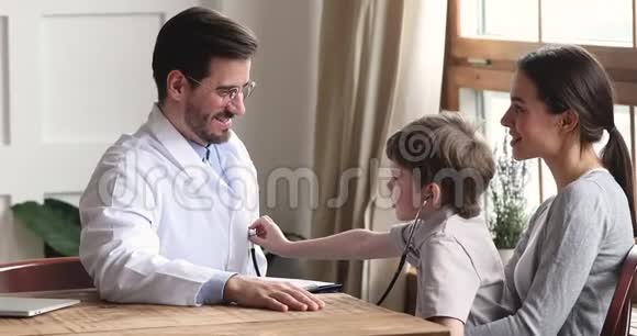 可爱的男童与手持听诊器的男医生玩耍视频的预览图