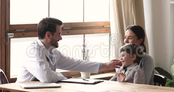 友好的有爱心的儿科医生和孩子在医疗访问期间交谈视频的预览图