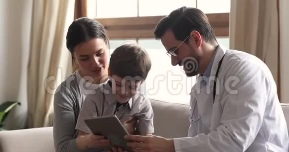 友好的男儿科医生咨询儿童儿童病人数字平板电脑视频的预览图