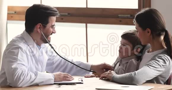 微笑男医生拿着听诊器检查听力男孩病人视频的预览图