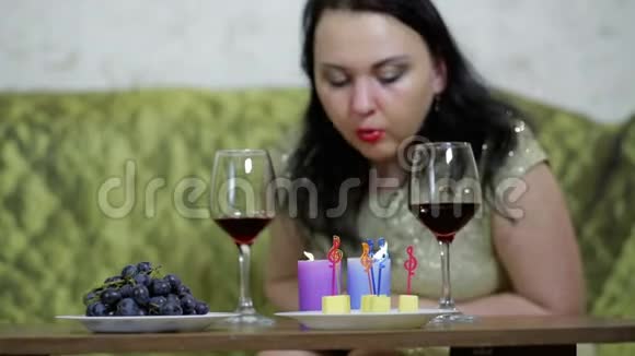 一个泪流满面的女人吹灭蜡烛擦眼睛把焦点从蜡烛转移到面部视频的预览图