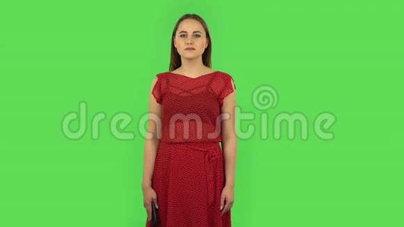 穿着红色衣服的温柔快乐的女孩在打电话绿色屏幕视频的预览图