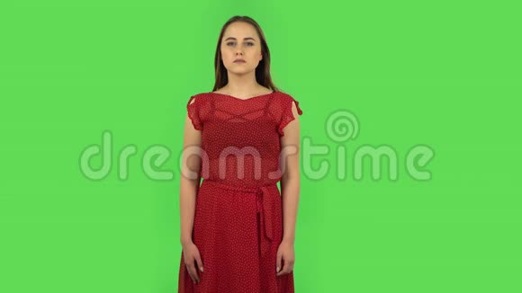 穿着红色衣服的温柔女孩被吓坏了然后宽慰地叹息微笑着绿色屏幕视频的预览图