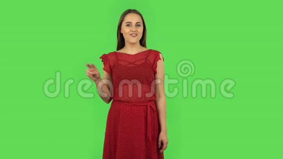 穿着红色衣服的温柔女孩正在展示两个手指的胜利手势绿色屏幕视频的预览图