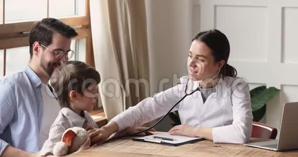 微笑女儿科医生拿着听诊器检查儿童男病人视频的预览图