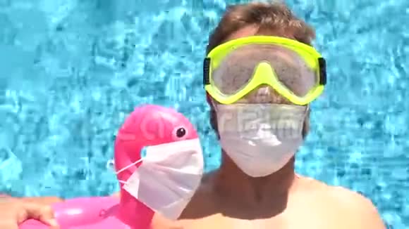 游泳池里的白人男性戴着医用口罩的玩具火烈鸟视频的预览图