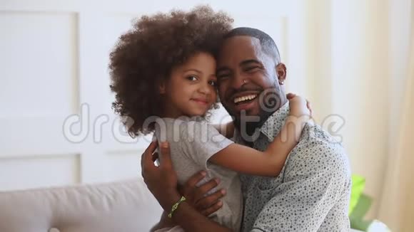 快乐的年轻非洲种族父亲拥抱可爱的小女儿视频的预览图