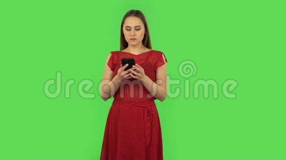 穿着红色衣服的温柔女孩在打电话绿色屏幕视频的预览图