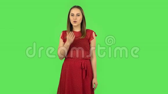 穿红色衣服的温柔女孩正在吹吻绿色屏幕视频的预览图