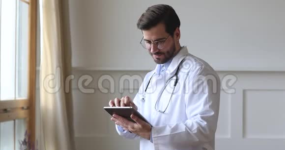 男性专业医生穿白色制服使用数码平板电脑视频的预览图