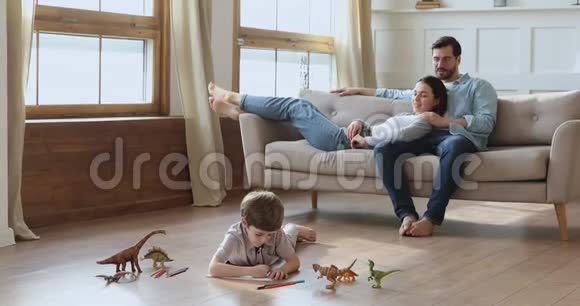 孩子在地板上画画父母在沙发上放松视频的预览图