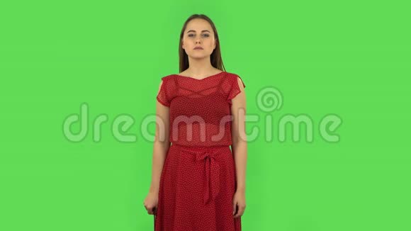 穿着红色衣服的温柔女孩正在用粉色指甲锉做指甲绿色屏幕视频的预览图