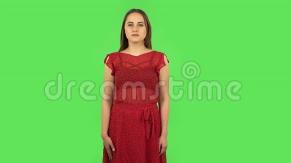红衣嫩嫩的女孩正站在期待中担忧然后欣慰地微笑着背着绿色屏幕视频的预览图