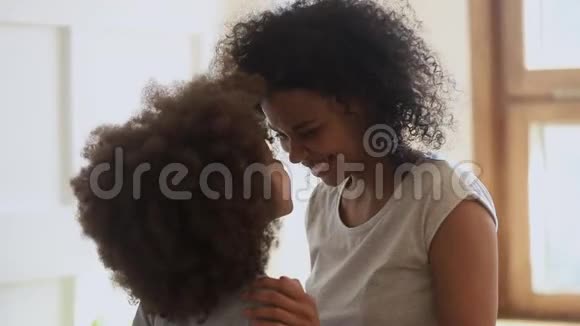 快乐的非裔美国女人和可爱的小女儿摸鼻子视频的预览图