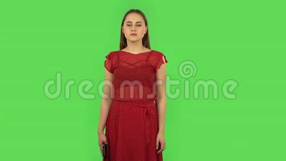 穿红色衣服的温柔女孩在为手机说话震惊了然后不满绿色屏幕视频的预览图