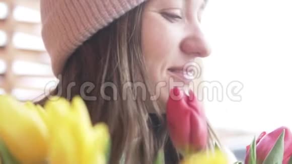 一个美丽的女人闻着一束在一个女人的日子里捐赠的郁金香视频的预览图