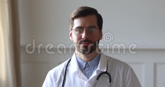 自信的男医生穿着白色制服看镜头特写镜头视频的预览图