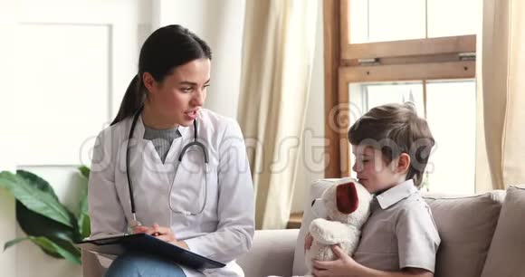 专业女医生与儿童病人交谈持有玩具视频的预览图
