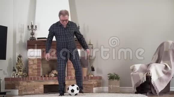 高加索退休人员在室内用足球进行愉快的现役训练积极健康的老人玩耍视频的预览图