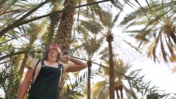 一个女孩走在阿联酋的棕榈种植园视频的预览图