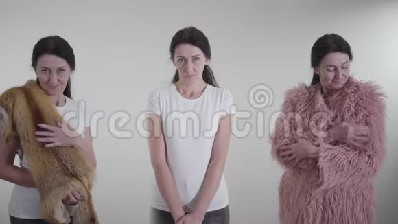 自然毛皮和生态毛皮的选择描述高加索黑发女人决定穿着的三重形象视频的预览图