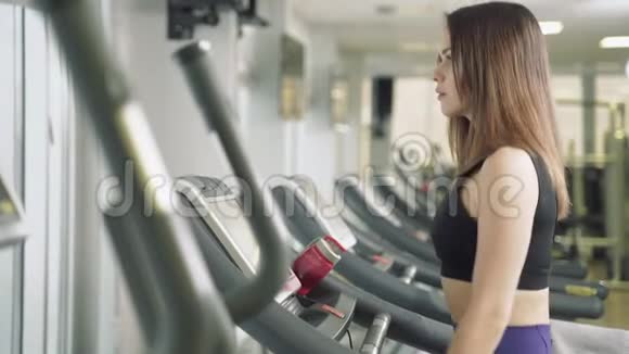 健身妇女在健身房跑步机上做有氧训练健身中心的运动女孩使用跑步机视频的预览图