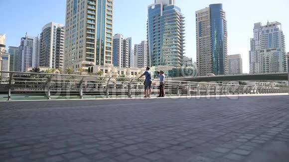 两个游客站在大城市的堤岸上视频的预览图