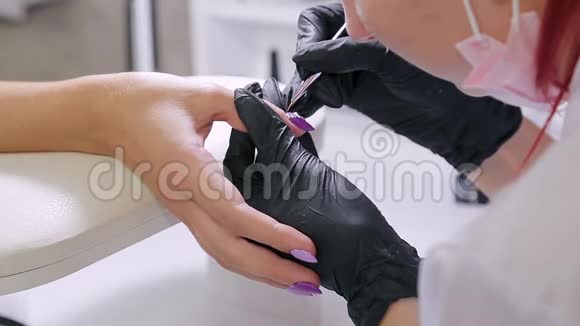 美容店里的摩尼教女人用莱茵石装饰客户指甲视频的预览图