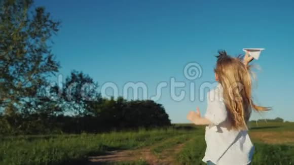 一个快乐的孩子手里拿着一架纸飞机在跑步快乐童年概念视频的预览图