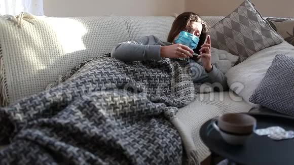 患流感或感冒的患病妇女打电话叫救护车的女孩躺在床上猫戴着保护面具用药丸和水视频的预览图