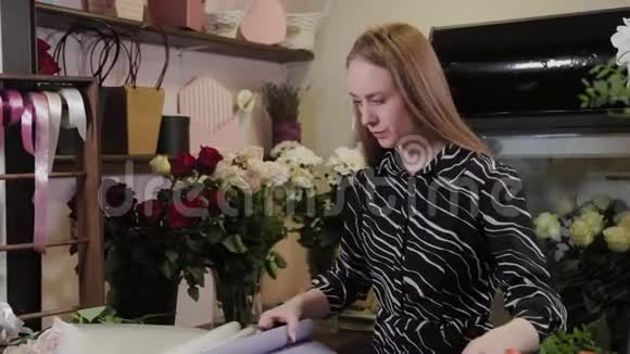 专业花艺师为鲜花准备包装为国际妇女节准备美丽的花束视频的预览图