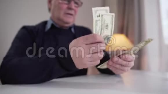 成熟的白种人男性手的特写数着现金把钱放在单独的束中令人担忧的退休人员视频的预览图