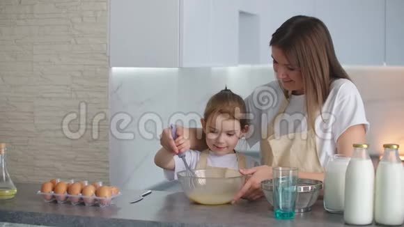 幸福的家庭在厨房里妈妈和女儿在厨房里玩面粉玩得开心在厨房里塑造馅饼视频的预览图