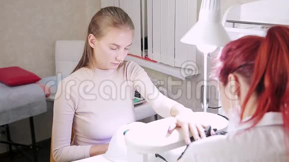 美容院的女美甲师在涂胶上涂了一层哑光视频的预览图