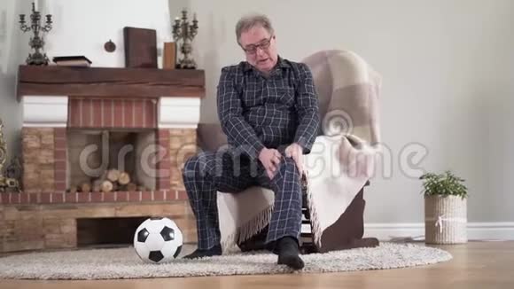 足球比赛后活动男性白种人退休人员摩擦伤膝的肖像戴眼镜的老人视频的预览图