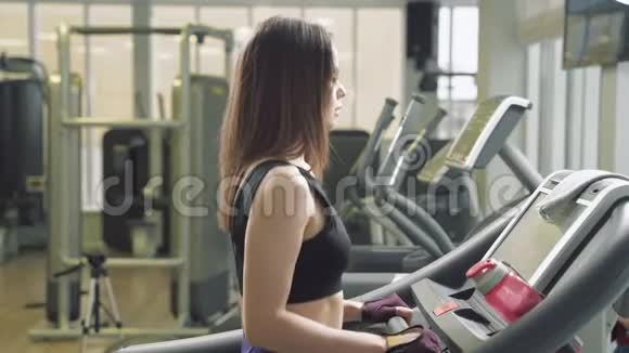 健身妇女在健身房跑步机上做有氧训练健身中心的运动女孩使用跑步机视频的预览图