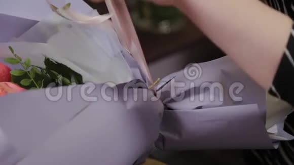 专业的花艺师用绸带系花束为国际妇女节准备美丽的花束视频的预览图