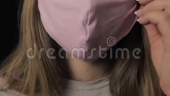 女孩摘下一个粉红色的面具开始咳嗽孤立在黑色背景上保健和医疗理念关门视频的预览图