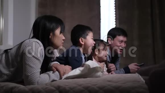 带着孩子看电视的欢乐亚洲家庭视频的预览图
