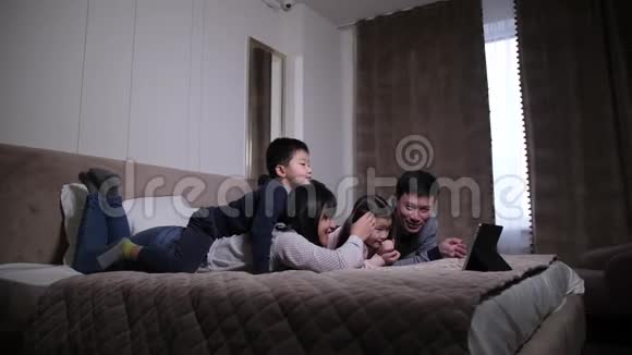 开朗的中国家庭在平板电脑上看电影视频的预览图