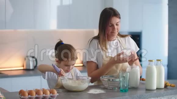 妈妈和她年轻的学前助理女儿一起在厨房做饭视频的预览图