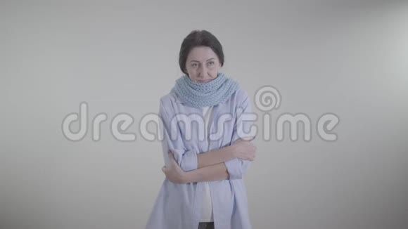 白人背景下咳嗽的病态白人妇女的肖像穿暖围巾患感冒和流感的深黑肤色女士视频的预览图