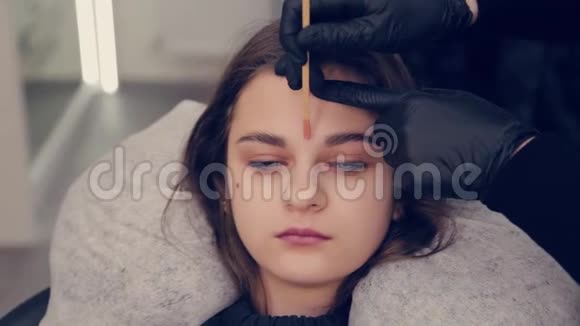 专业主眉妇女做脱毛与蜡眉对客户在美容院视频的预览图