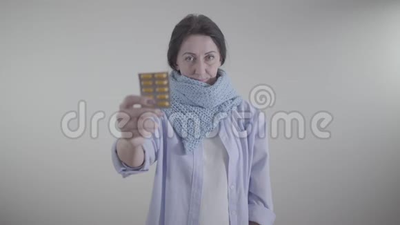 白人成年妇女拿着模糊的水泡药片的肖像布鲁内特小姐在镜头前看药视频的预览图