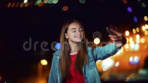 青少年女孩在傍晚城市景观背景与路灯boke制作自己的肖像视频的预览图